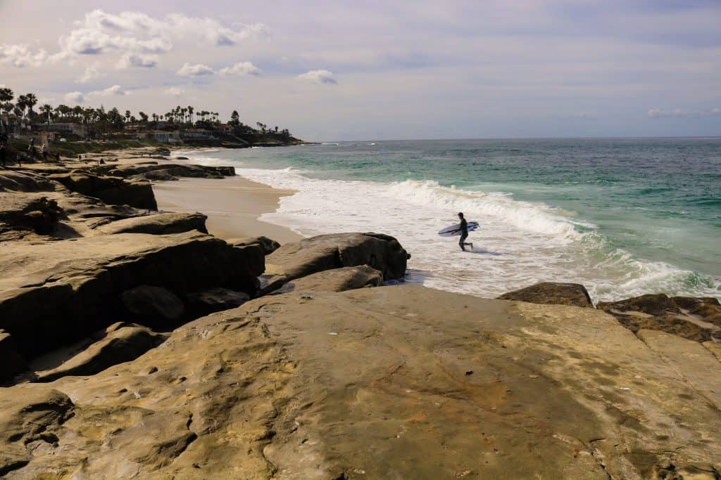 A surfer exciting the ocean at Windansea Beach.