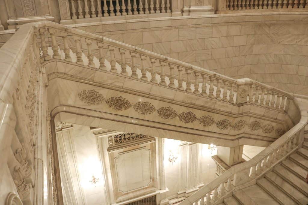 A grand marble staircase inside the Palace of Parliament.