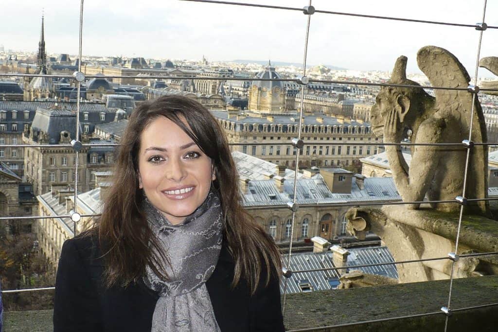 Traveling Ness enjoying the view from the top of Notre Dame Cathedral in Paris with the gargoyle in the shot.