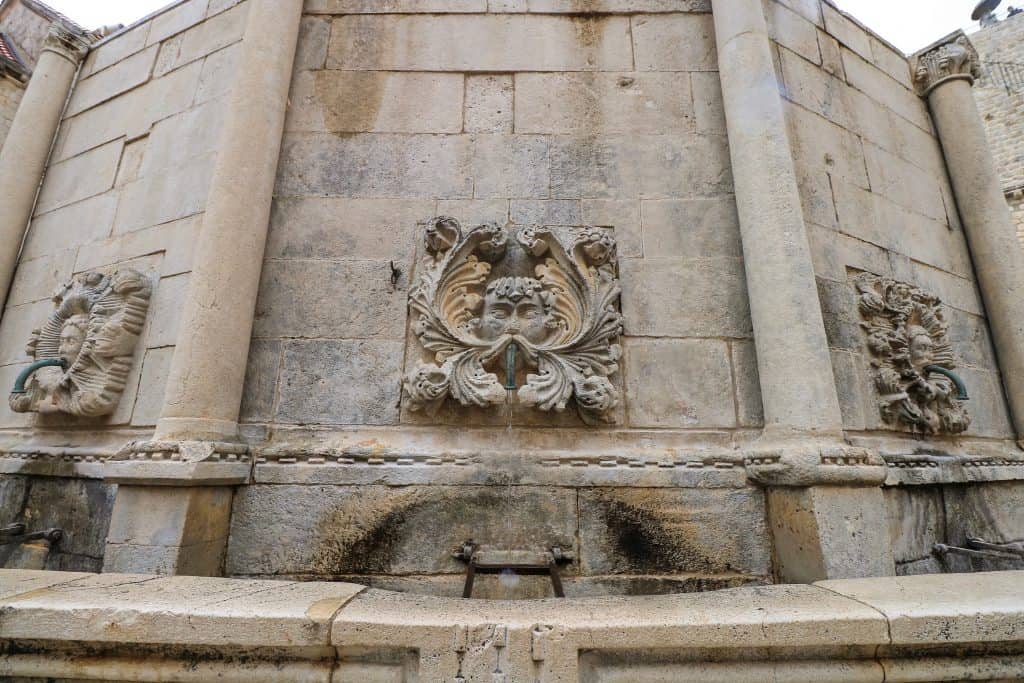 One of 16 masked faces that is also a water spout