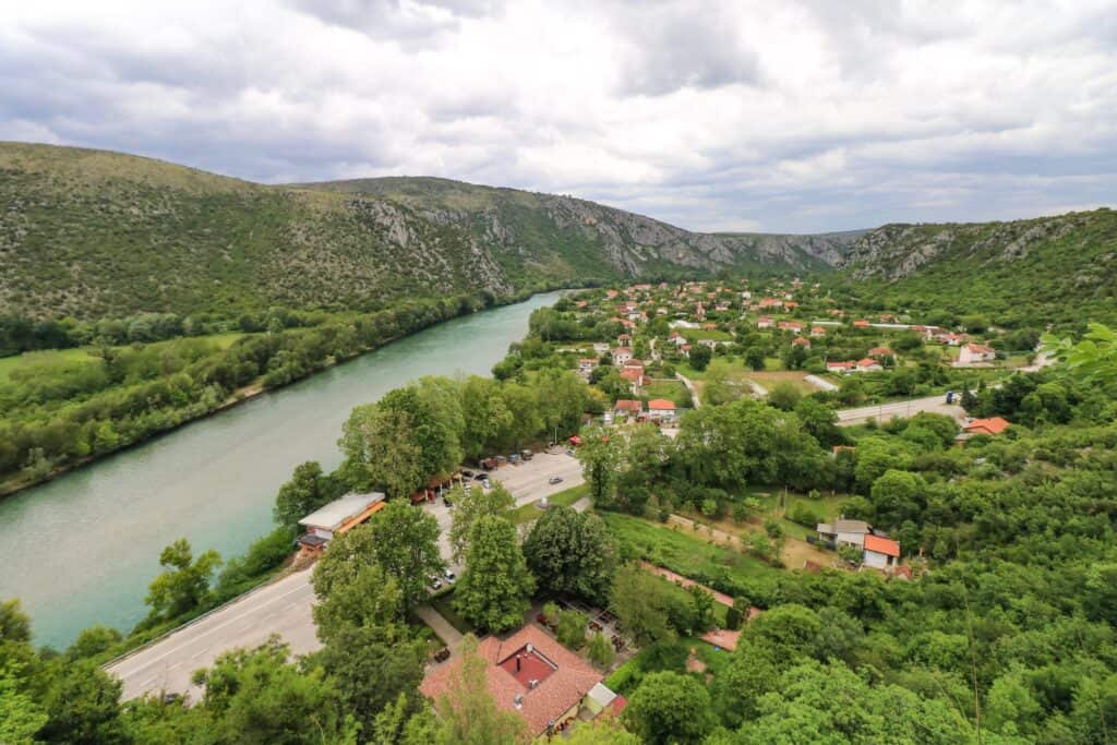 Looking down at the Neretva River with lush green foliage on each side of the river in Bosnia.