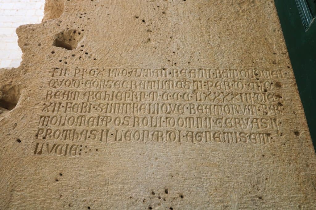 A large stone slab with a few sentences carved into it in the Temple of Jupiter ruins in Split old town.