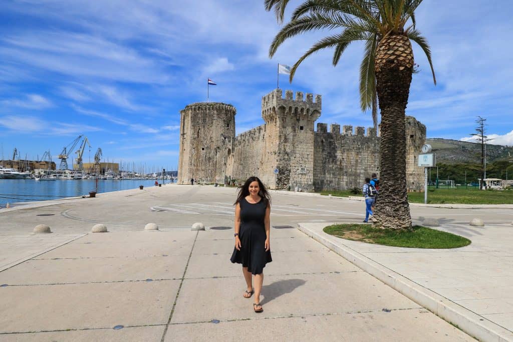 Strolling along the promenade in Trogir with the Kamerlengo Fortress behind me.