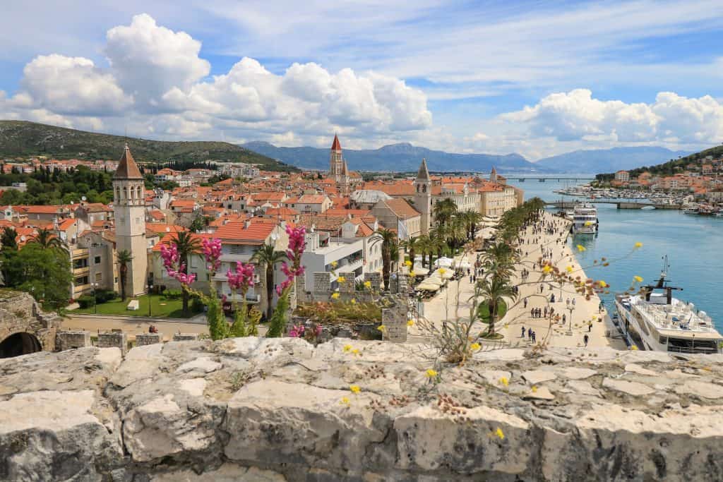 View of Trogir, the sea with boats passing and bell towers from the top of Kamerlengo Fortress.
