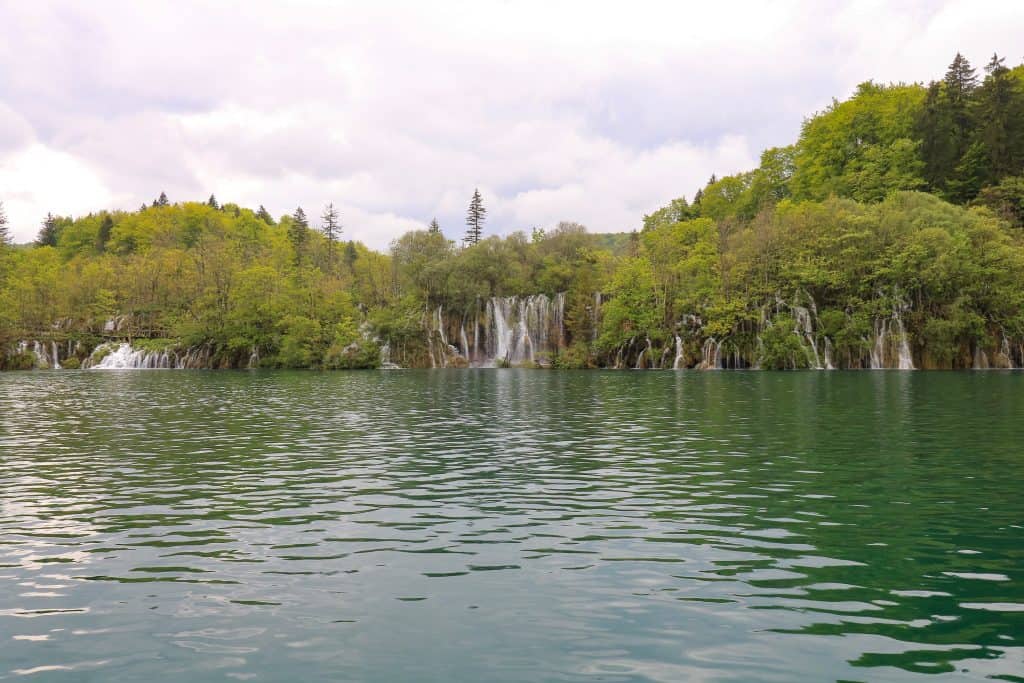 A handful of small waterfalls flowing into Lake Kozjak seen from the ferry boat.