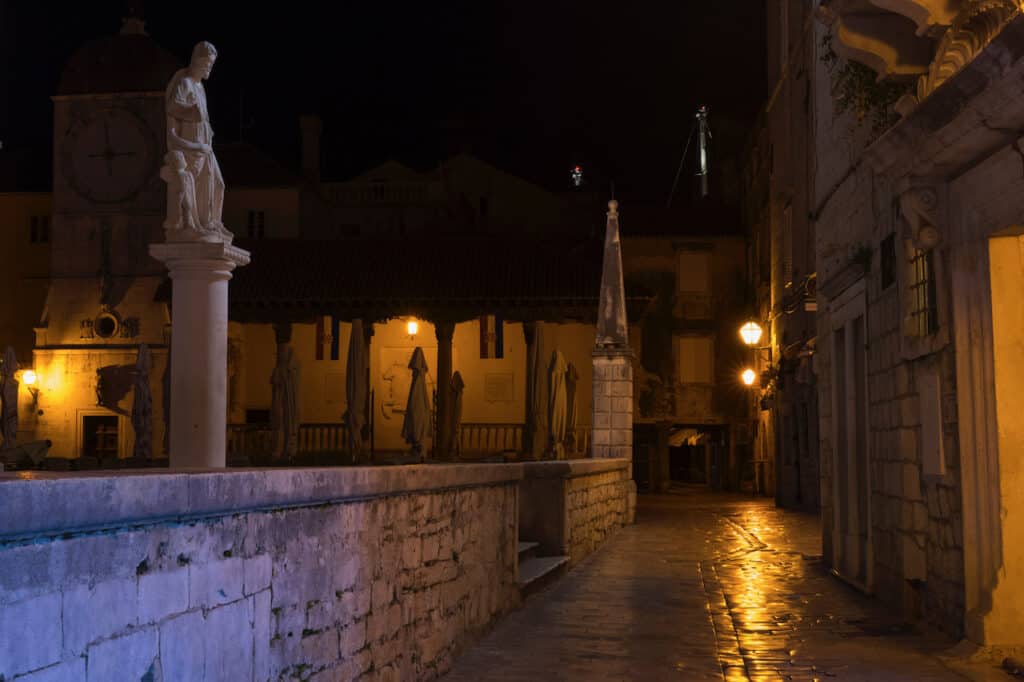 A dimly lit cobblestoned walkway in the old town section of Trogir, Croatia.