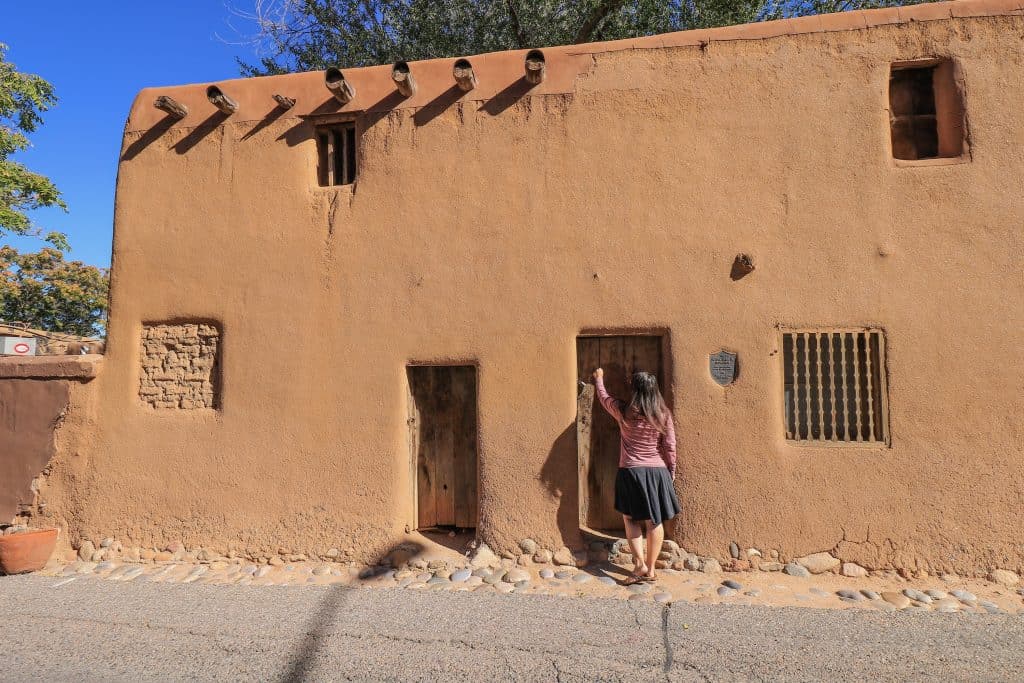 Me knocking on a wooden door at the oldest house in Santa Fe, New Mexico.