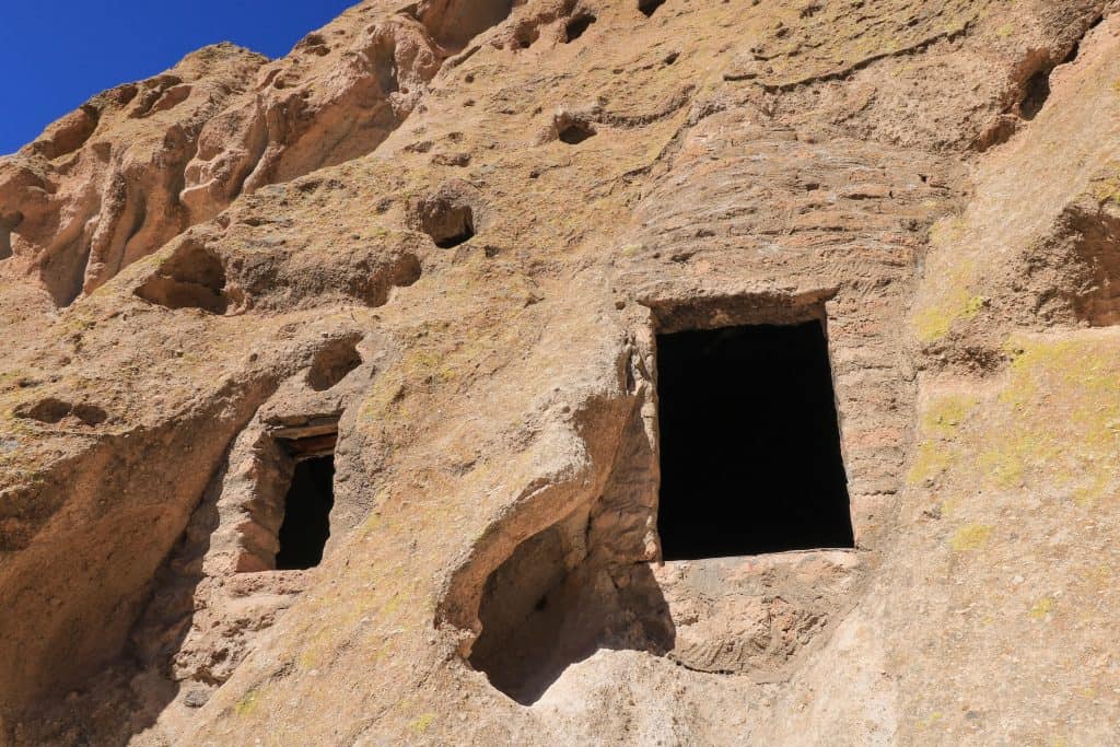 One of many cave dwelllings along the cliffs with a door and window carved out.