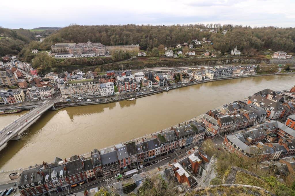 A close-up bird's eye view of the colorful buildings, Meuse River and bridge from the top of the citadel in Dinant.