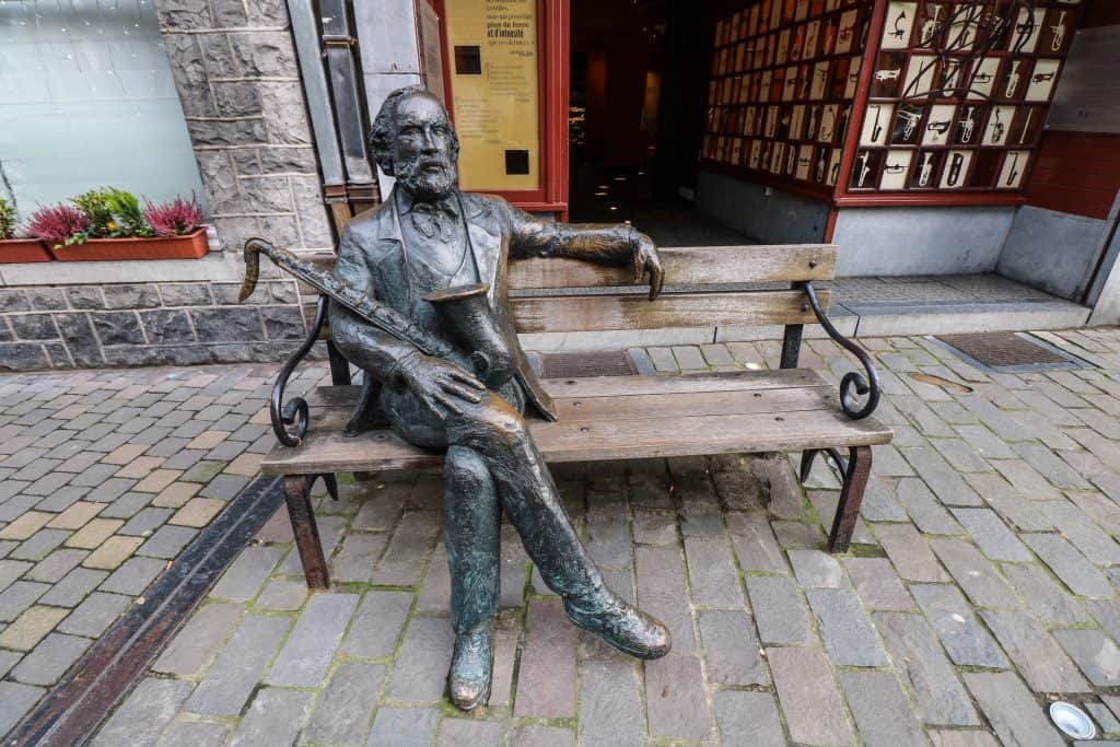 A statue of the saxophone's inventor Aldophe Sax sitting on a bench in front of the museum which was once his home in the city of Dinant, Belgium.