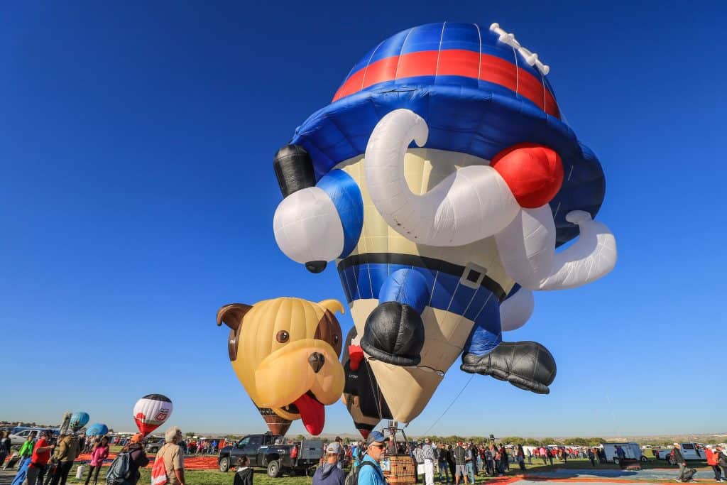 A policeman and puppy balloons having fun