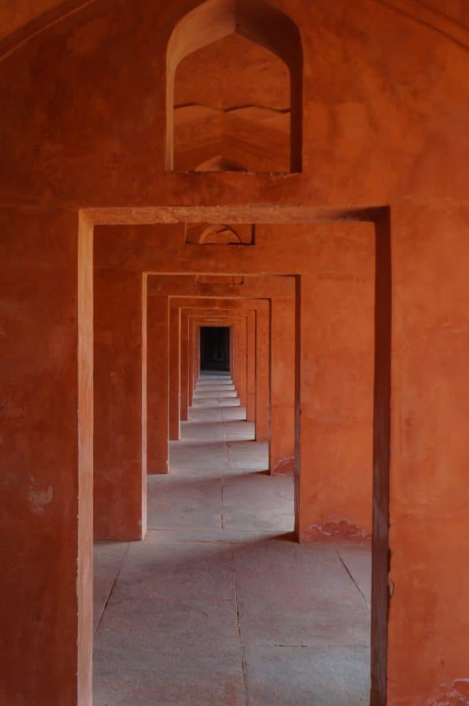 A walkway with a series of square archways in red sandstone