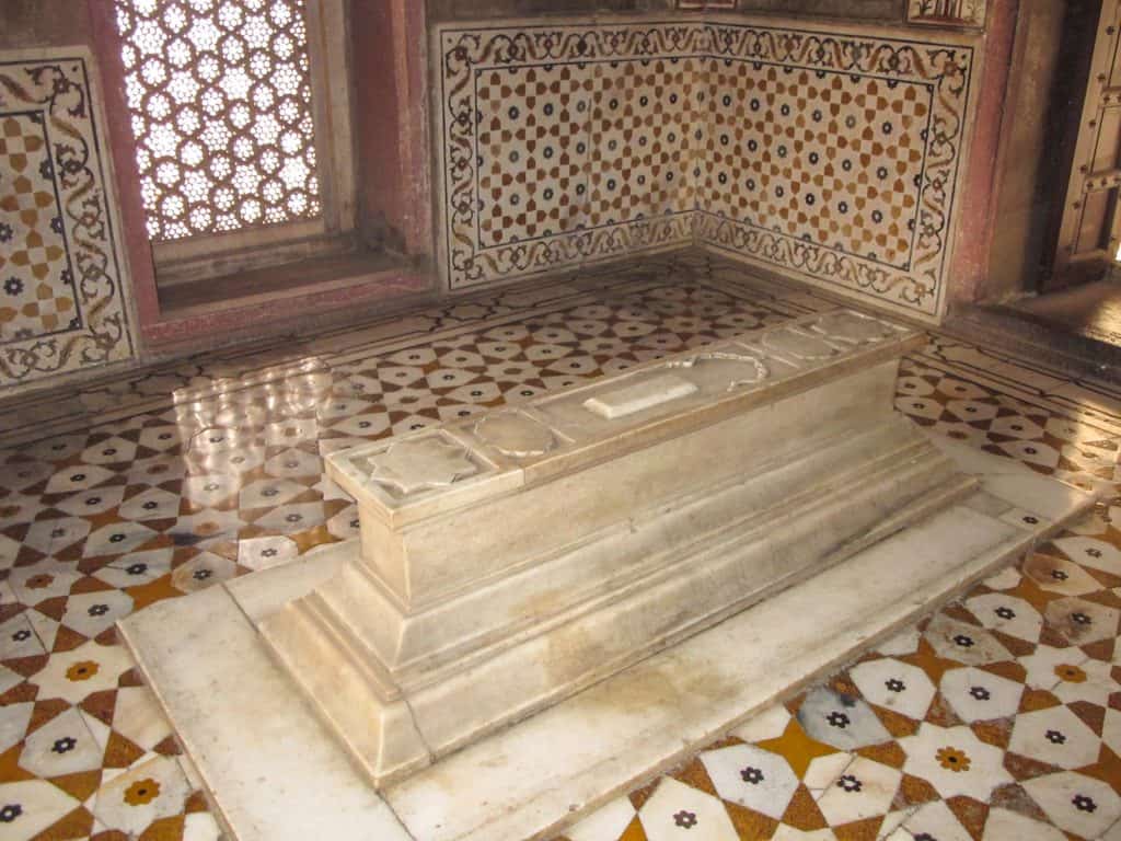 a marble tomb surrounded with decorative inlays on the walls and floor