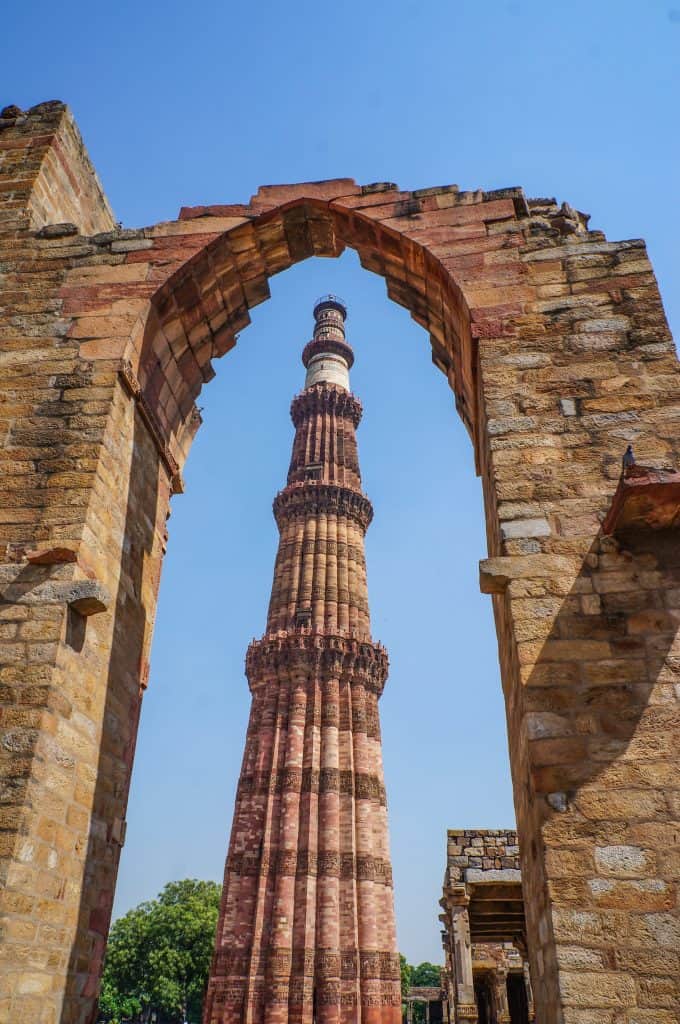The Qutub Minar is the tallest brick minaret tower in the world in various shades of red and tan colors and detailed carvings in the entire tower