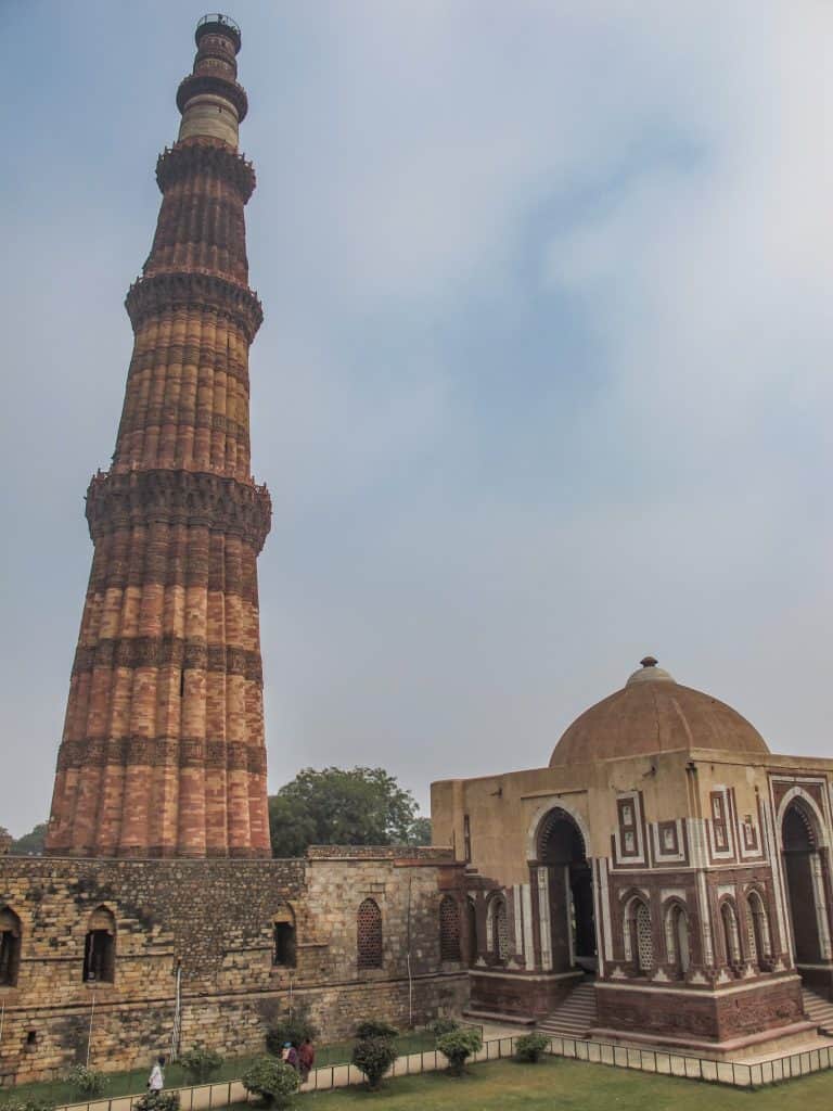 The tall minaret tower of Qutub Minar made of red sandstone and intricate carvings located that is a must to see on this Delhi itinerary