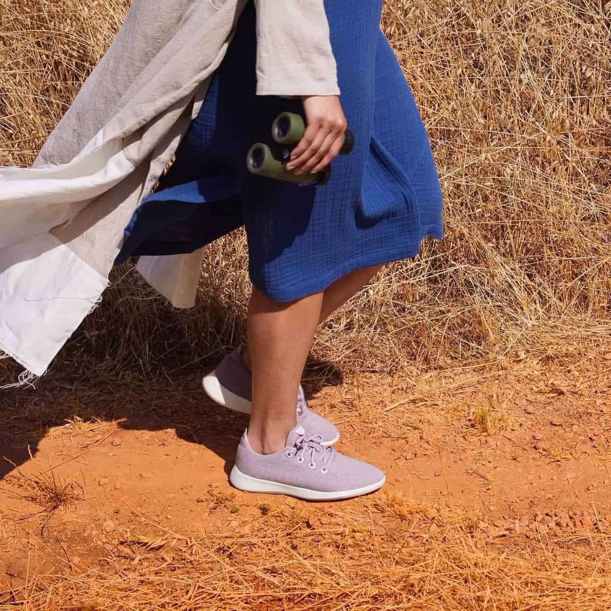 woman walking outdoors wearing a pair of Allbirds shoes