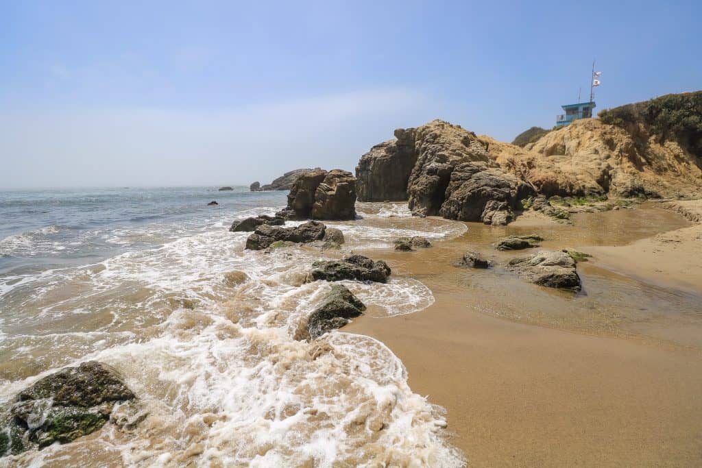 The rocky outcrop, lifeguard tower and crashing waves on Leo Carrillo State Beach in Malibu, California.
