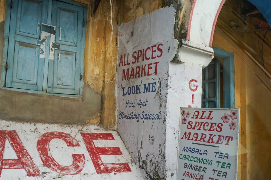 Advertising for a spice market in colorful paint of yellow, red, blue and white along a street in Kochi.