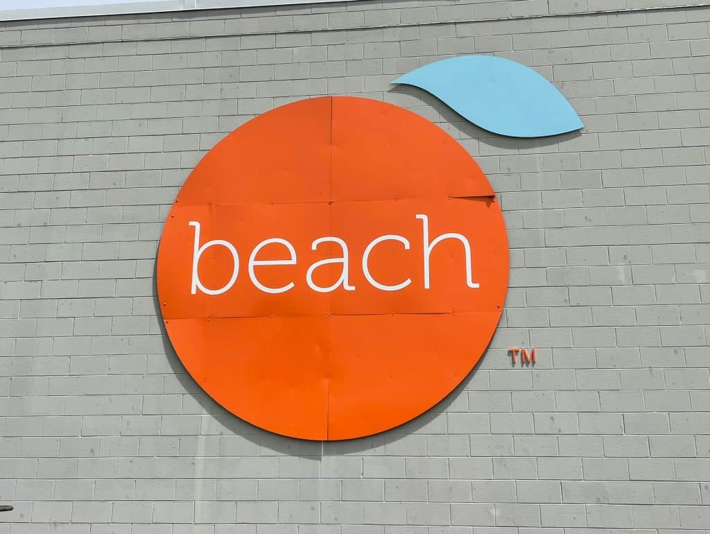 A huge bright orange colored orange that has the word "beach" on it to symbolize the city of Orange Beach, Alabama.