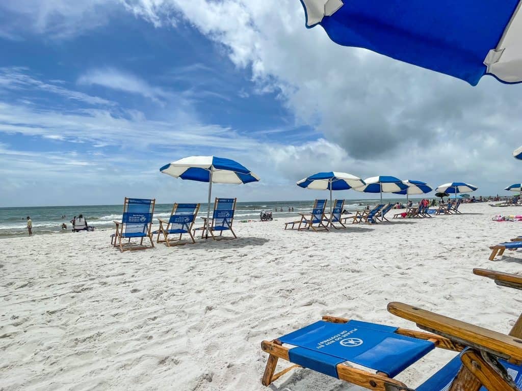 Sitting in a beach lounge chair relaxing with rows of other lounge chairs in view on a sunny day at Orange Beach, Alabama.
