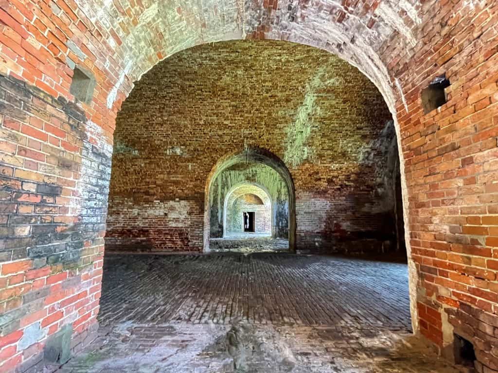 A series of arched brick walkways in the tunnel of Fort Morgan.
