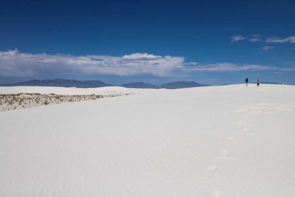 Two kids wandering and playing on the white sand dunes