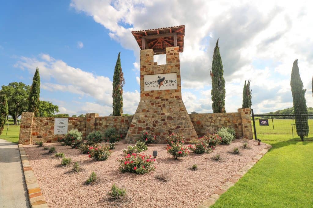 Beautiful entrance to Grape Creek Vineyard with a huge Tuscan themed stone pillar greeting you to the winery.