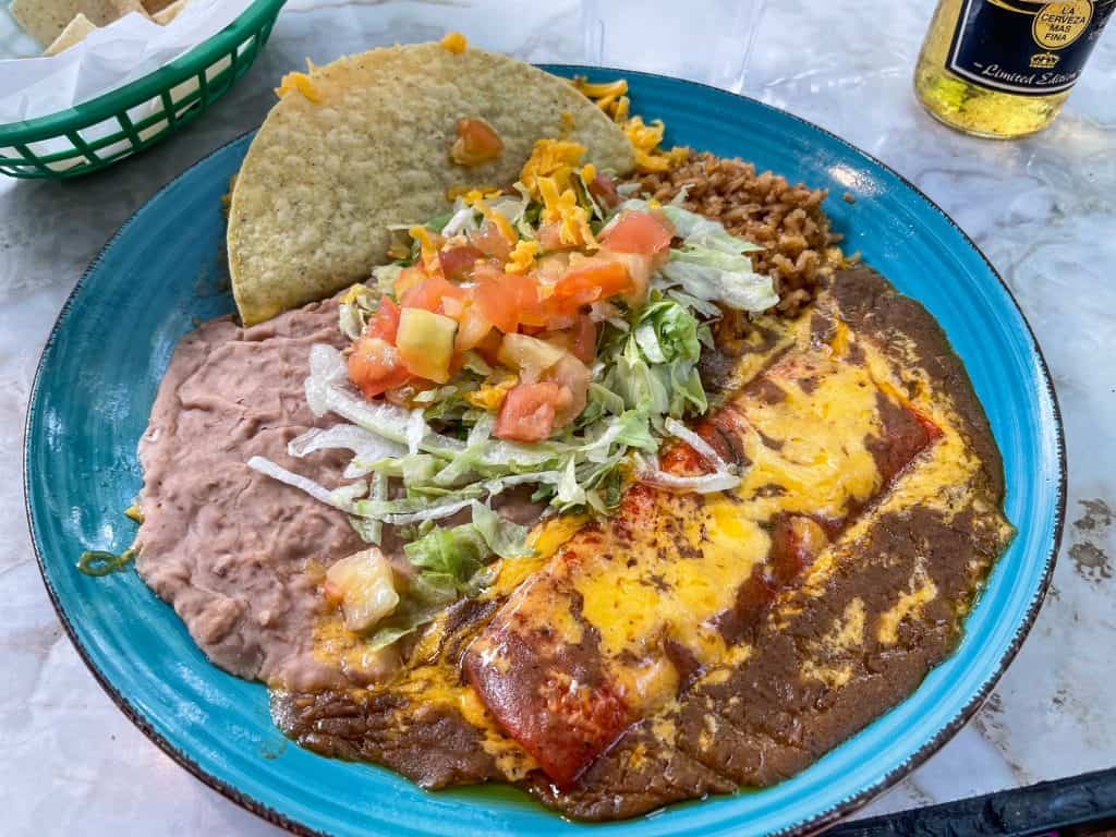 A huge plate of Mexican food including a taco, enchilada and rice and beans from Rita's on the River Walk.
