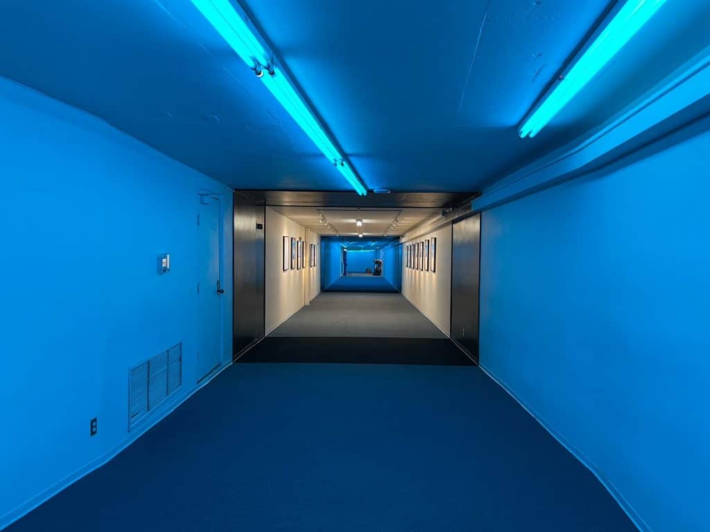 Walking in a blue lit part of the Underground Tunnel.