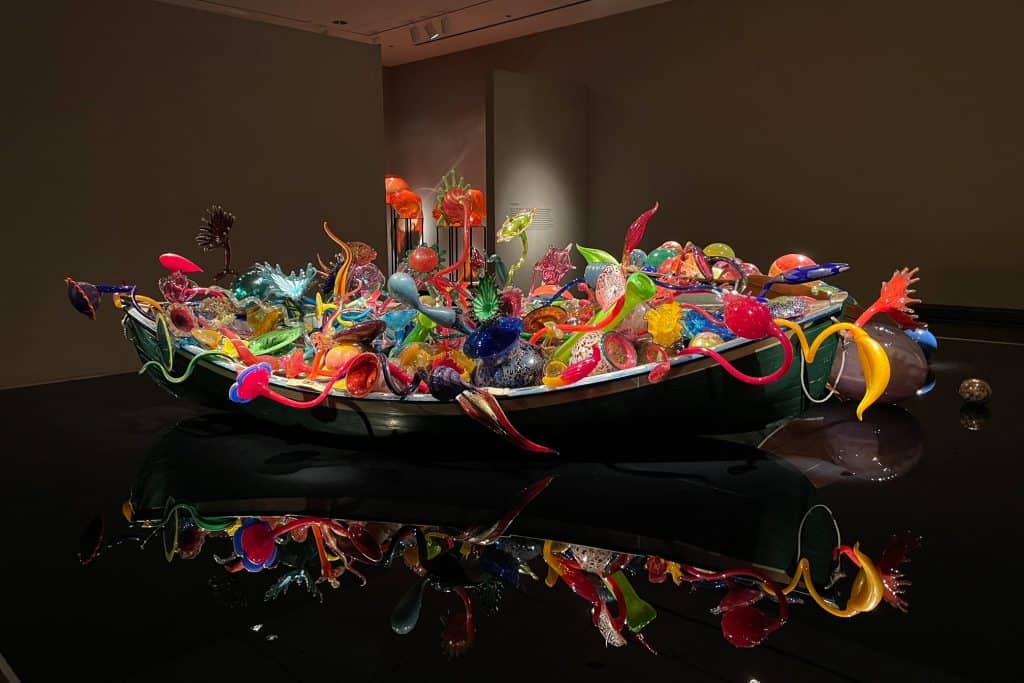 An incredibly huge glass blown sculpture of various shapes and colors in a boat at the Chihuly art exhibit at the OKC Museum of Art.
