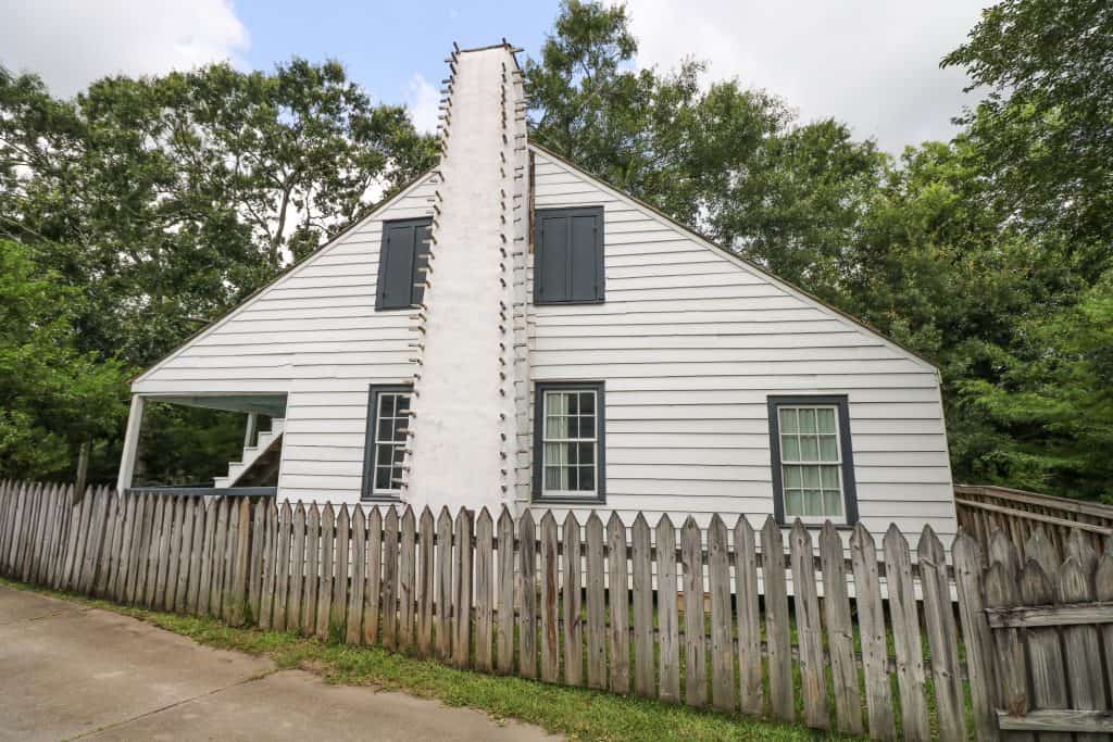 A white house bordered by a wooden fence in Vermilionville.