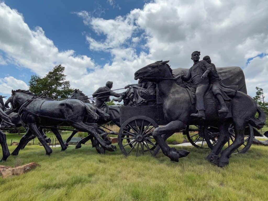 A side view of the huge bronze statues of people on horseback for the Land Run of 1889.