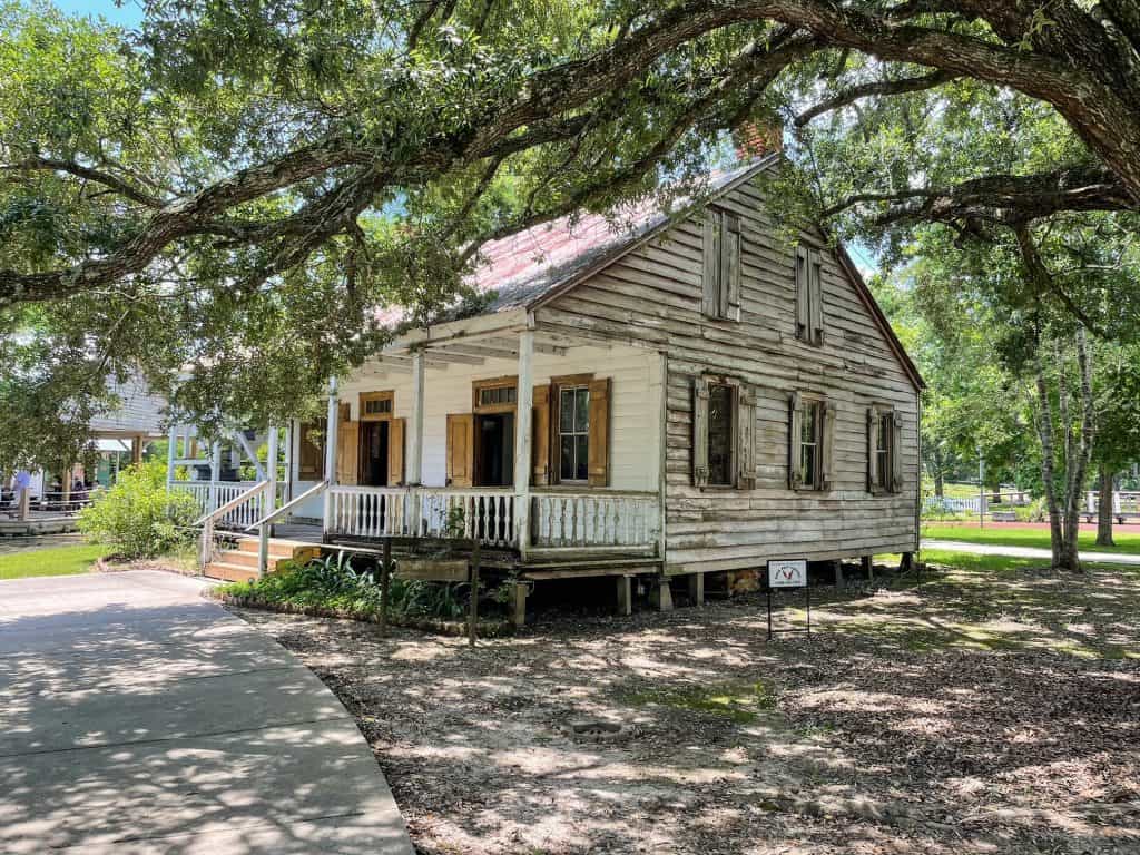 A charming white wooden Acadian house in Acadia Village is one of many fun things to do in Lafayette also known as Louisiana's Cajun country!