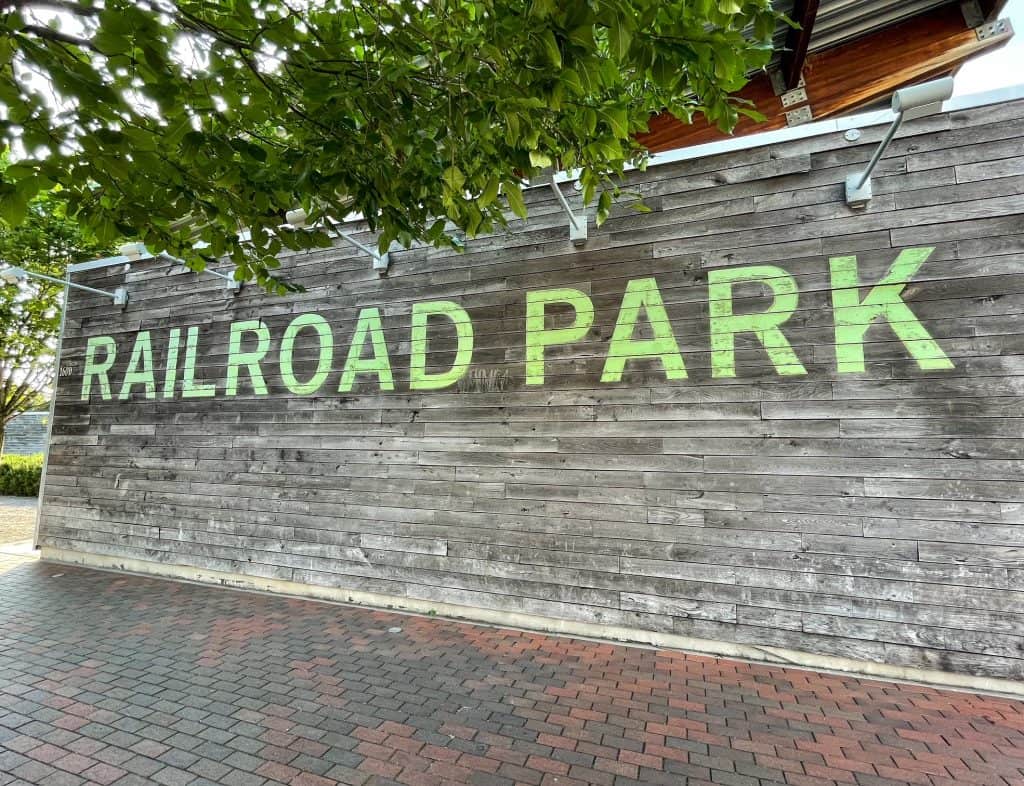 Huge green letters against a wooden wall that says Railroad Park at the park entrance.