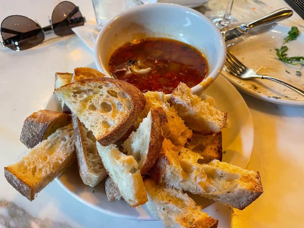 A small bowl of Beef Fat Candle with pieces of bread to dip in it.