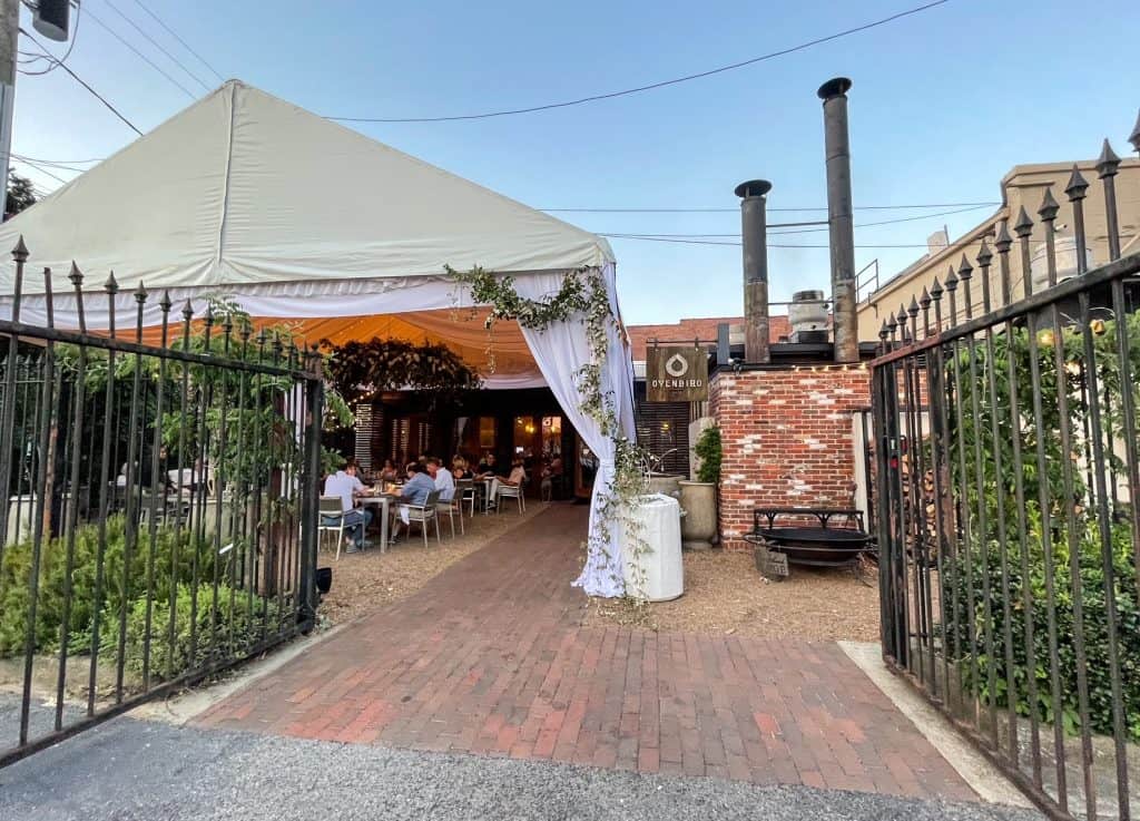 View of the charming outdoor patio and entrance to Ovenbird Restaurant in Birmingham.