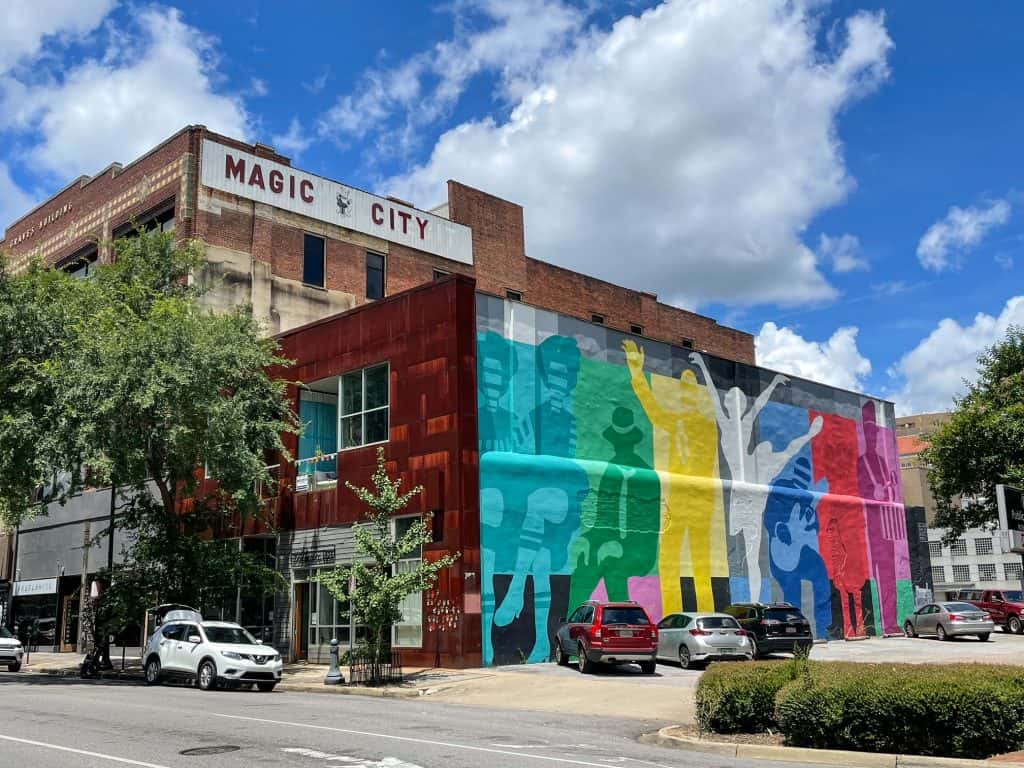 Magic City painted above a bright colored mural with artists and a ballerina in the Theatre District in downtown Birmingham.