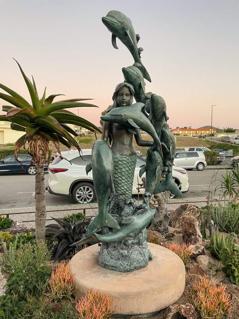 A beautiful statue of a mermaid and dolphins along the waterfront in downtown Morro Bay.