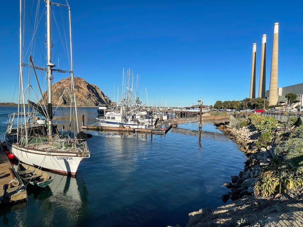 View of various boats with Morro Rock and the 3 stacks behind.