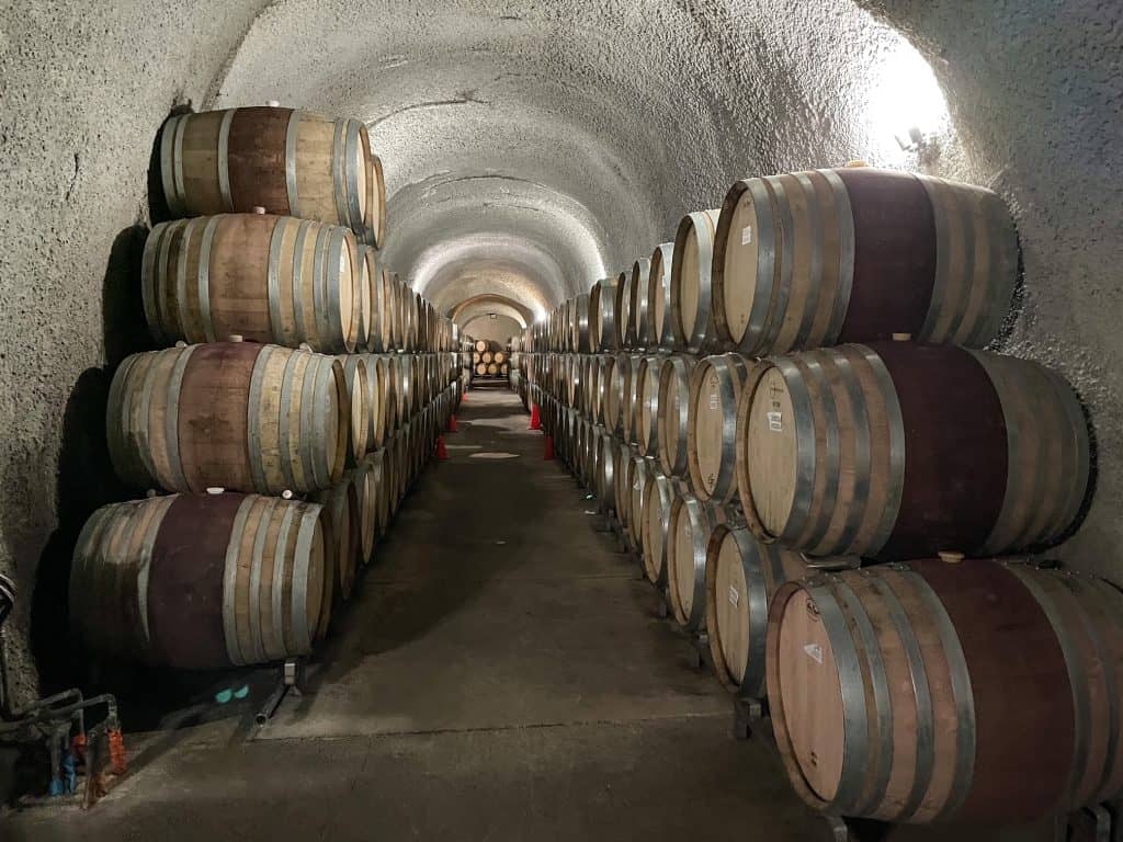 Walking through the wine caves lined with barrels of wine.
