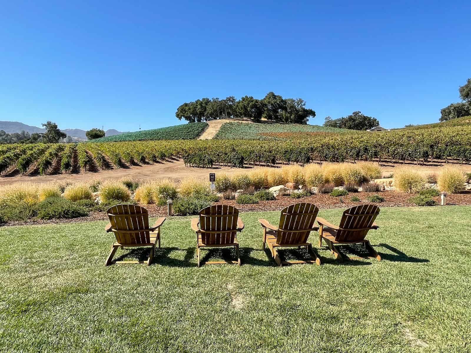 Four chairs on a grassy area made of old wine barrels at a winery in Paso Robles.