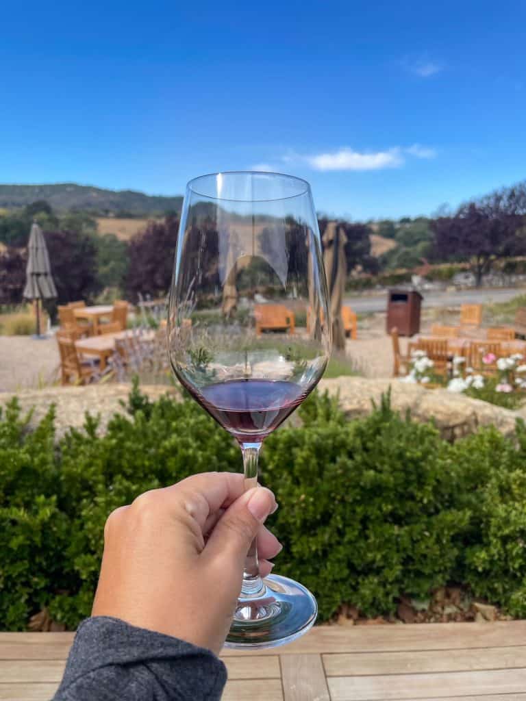 Holding a glass of red wine at Denner Vineyards in Paso Robles.