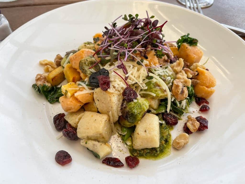 A delicious and colorful meal of gnocchi, fresh vegetables and currants.