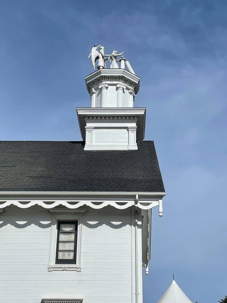 A close-up view of the statues on top of a white building in the town of Mendocino.