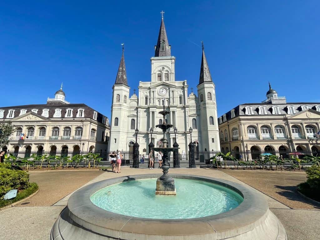 Standing in front of a fountain with the cathedral behind it and the Cabildo next to it in Jackson Square.