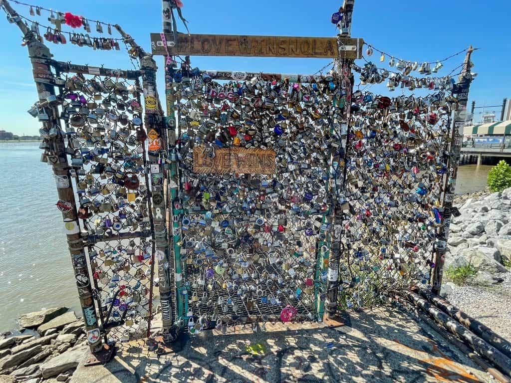 A section of chainlink fence with several locks on it known as Love Wins Locks.