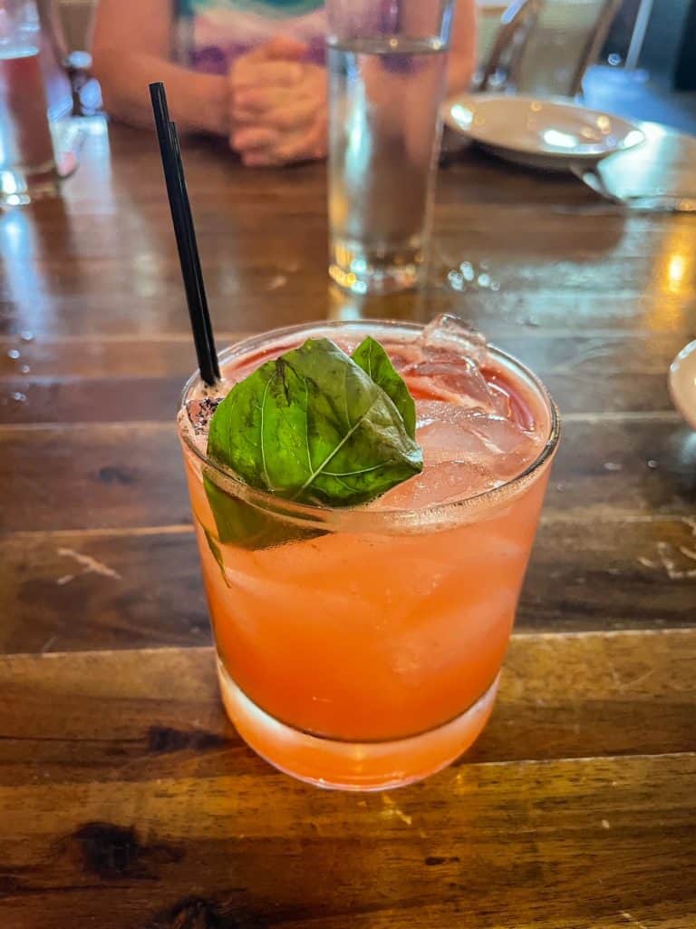 A peach colored cocktail on a food tour.