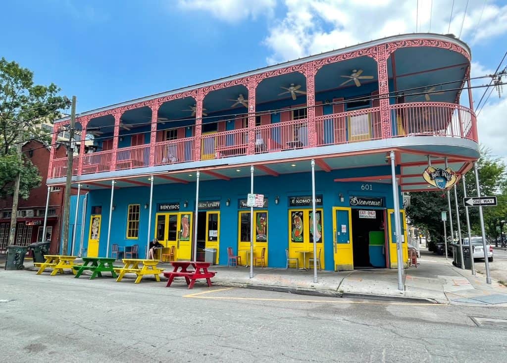A 2-story colorful pink, blue and yellow building on Frenchmen Street.