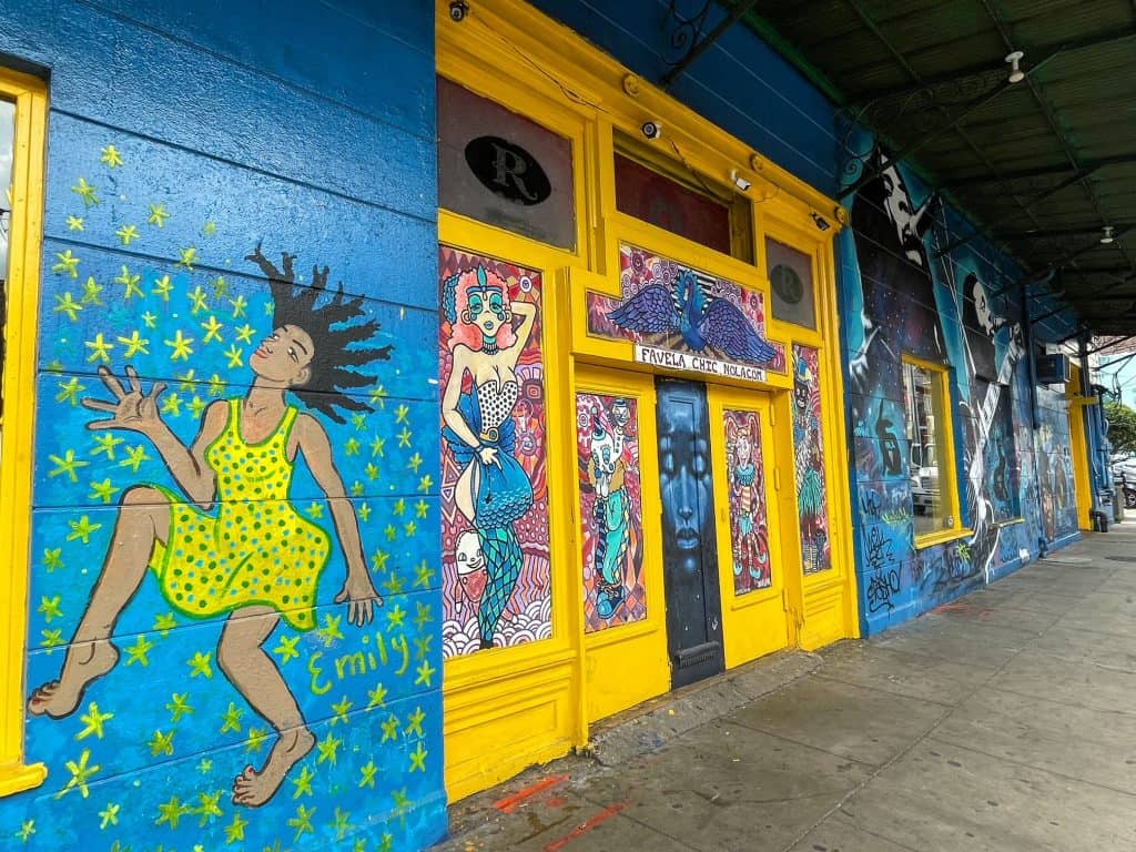 A colorful blue and yellow art mural of people dancing and playing jazz on Frenchmen Street.