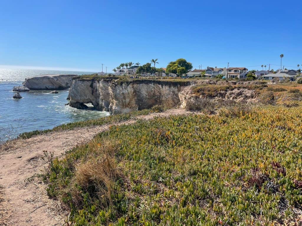 Walking along the dirt trail along the coastal bluffs looking at the beautiful cliffs and ocean at Dinosaur Caves Park in Pismo Beach.